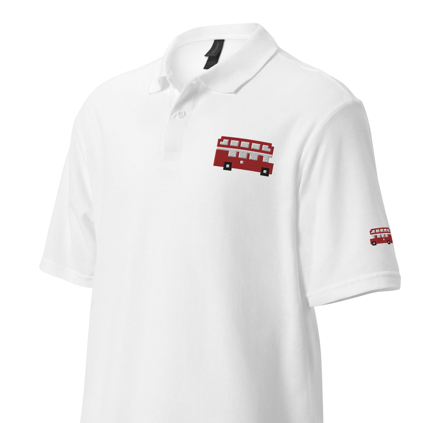 White polo shirt featuring a pixel art design of a classic red London double-decker bus on the chest, with a smaller matching bus detail on the sleeve. The 8-bit style bus adds a playful and iconic British element to the clean, casual look of the shirt